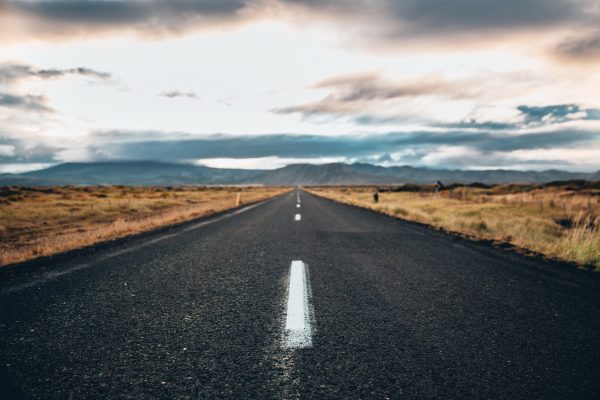 asphalt clouds driving grass hills journey mountains outdoors pavement road rural sky travel tundra free photo CC0