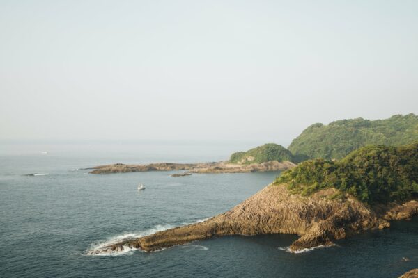 Aerial boat Cliff Coast coastline cove forest Island Mist nature Ocean outdoors sea shore travel trees water Waves free photo CC0