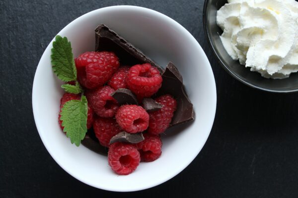 picography top view of raspberries chocolate and mint in white dish