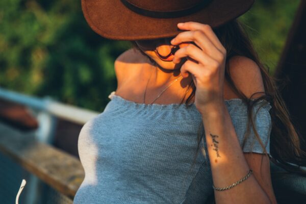 Accessories belly casual Fashion female Fence girl Hat leaning Model nonchalant outdoors Person Relaxing smiling Style Stylish summer sunglasses Sunlight tattoo trees Warm woman free photo CC0