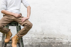 picography-man-in-work-boots-sitting-rustic-wall