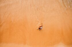 picography-one-man-lounges-on-the-beach-at-the-water-s-edge