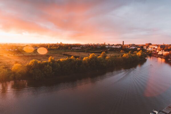 Aerial calm cloudscape copy space Dawn Dusk field flare golden Lens peaceful reflection River shore Sunlight sunset trees village Warm water free photo CC0