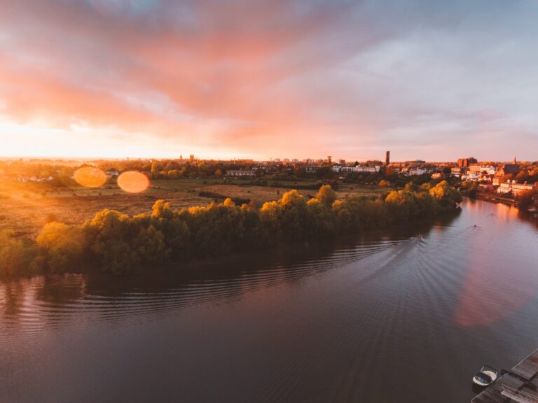 Aerial calm cloudscape copy space Dawn Dusk field flare golden Lens peaceful reflection River shore Sunlight sunset trees village Warm water free photo CC0